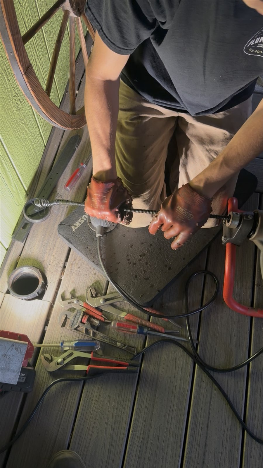 Bryan Ince Plumbing technician using a drain snake to clear a clogged drain in Alpine, CA
