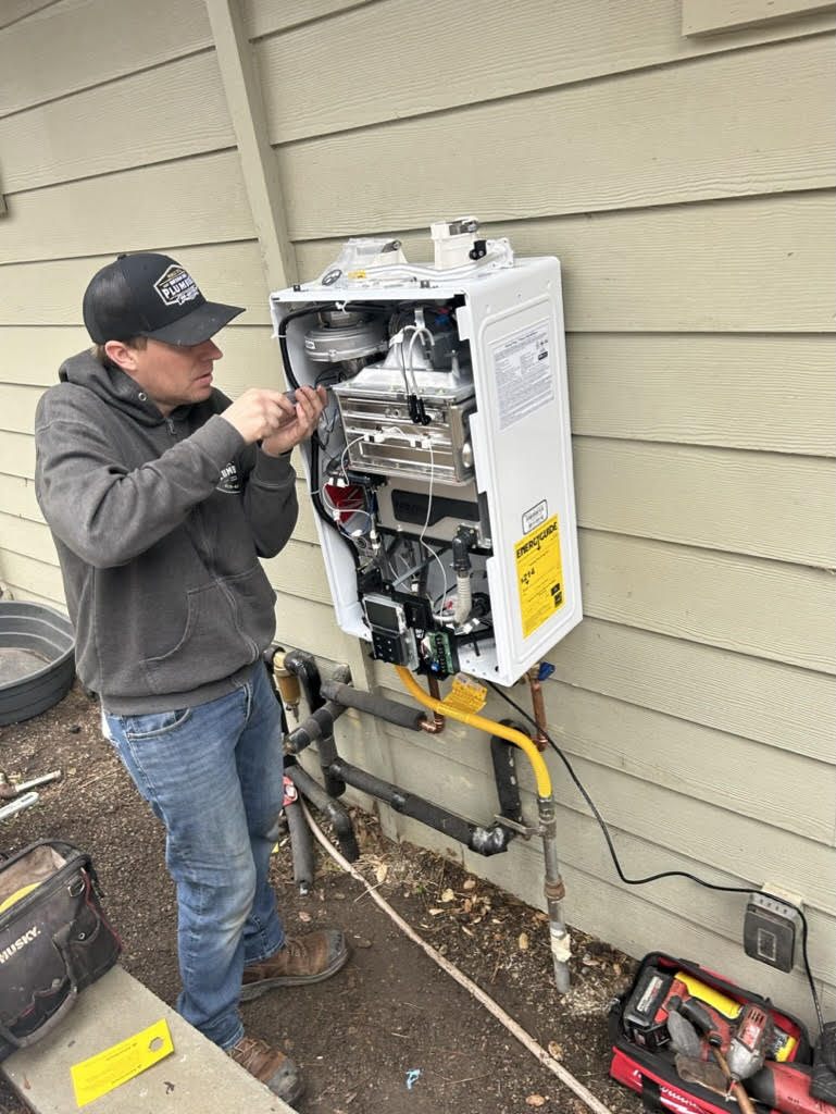 Bryan Ince Plumbing technician servicing a tankless water heater unit